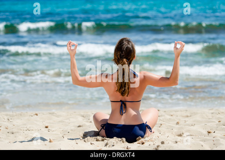 Frau im Bikini Joga macht am Strand, Spanien, Ibiza - femme ne le yoga à la plage, Ibiza, Espagne Banque D'Images