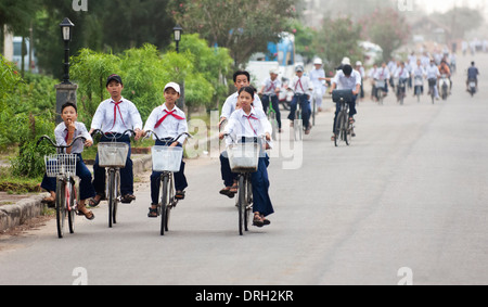 Les enfants de divers groupes d'âge scolaire à l'école à vélo, Hoi An, Vietnam Ann Banque D'Images