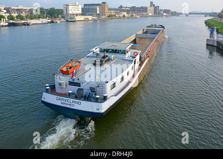 Maastricht Limburg vue du dessus calme de la rivière Meuse (rivière Maas) long vide vraquier moteur barge passant le long du paysage urbain aux pays-Bas UE Banque D'Images