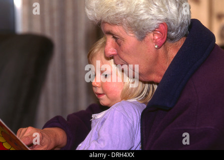 Grand-mère à sa petite-fille de lecture Banque D'Images