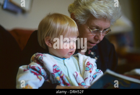 Grand-mère à sa petite-fille de lecture Banque D'Images