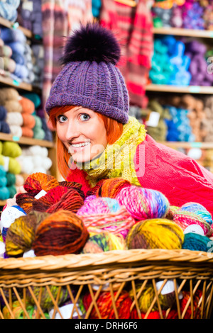 Jeune femme l'achat de laine et de fils colorés pour leur passe-temps dans une boutique de tricot Banque D'Images