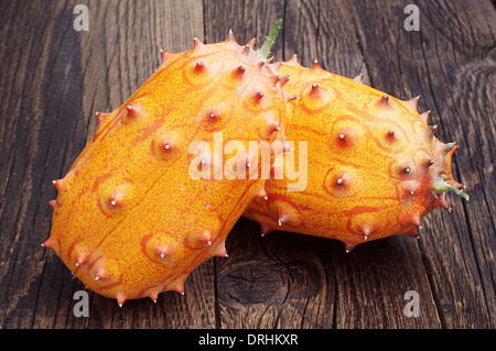 Deux fruits Kiwano - melon à cornes d'Afrique ou de concombre sur la vieille table en bois Banque D'Images