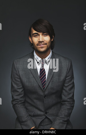 Portrait de jeune homme à la caméra à l'exécutif en toute confiance. Handsome asian businessman sur fond noir. Banque D'Images