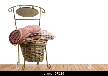 Panier en osier plein de serviettes propres sur une table en bois, sur fond blanc Banque D'Images