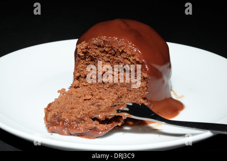 Éponge chocolat dessert couvert de sauce chocolat chaud - studio shot Banque D'Images