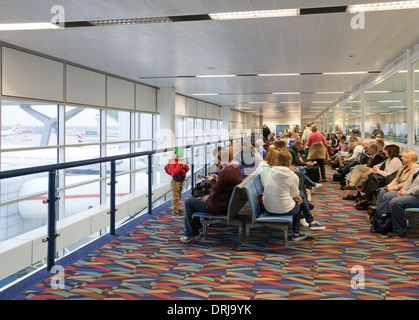 L'aéroport de Gatwick North Terminal passagers en attente dans la zone de départ. Non aiguisé Banque D'Images