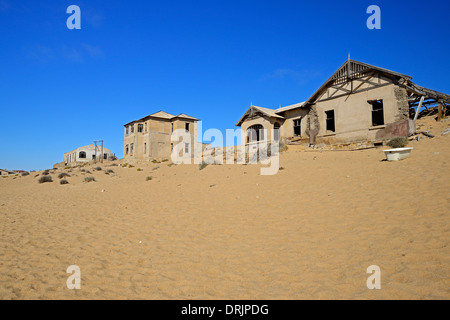 Les dunes de sables du désert et pris des bâtiments résidentiels, les bâtiments de travail dans l'ancienne ville de diamants de Kolmanskuppe, Kolmansko Banque D'Images