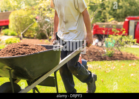 L'exécution d'un paysagiste de paillis de jardin brouette Banque D'Images