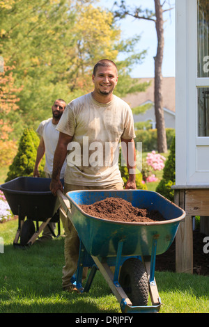 Paysagistes exerçant son activité sous paillis pour un jardin en brouette Banque D'Images