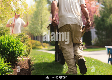 L'exécution d'un paysagiste de paillis de jardin brouette Banque D'Images
