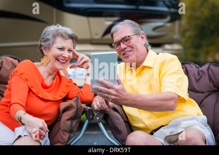 USA, Texas, Senior couple devant leur véhicule récréatif à l'aide d'un mini tablet pc Banque D'Images