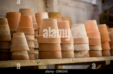 Pots de plantes en terre cuite empilés sur une étagère à pots. Banque D'Images