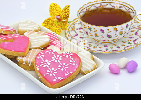 Les cookies en forme de coeur glacé à l'heure du thé avec un ancien de la Chine. Banque D'Images