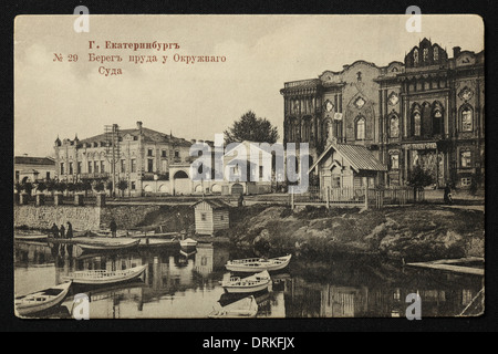 Tarasovskaya Embankment de la rivière Iset près du tribunal de district de Yekaterinburg, Empire russe. Photo vintage noir et blanc du photographe russe Veniamin Metenkov datée du début du XXe siècle, publiée dans la carte postale russe vintage publiée par Veniamin Metenkov lui-même à Yekaterinburg. Texte en russe: Yekaterinburg. La banque de l'étang près du tribunal de district. La rivière Iset forme l'étang de la ville (Gorodskoy Pond) dans le centre-ville de Yekaterinburg. Le tribunal de district aussi connu sous le nom de Maison de Sevastianov ou la Maison du Syndicat est le monument architectural du XIXe Banque D'Images