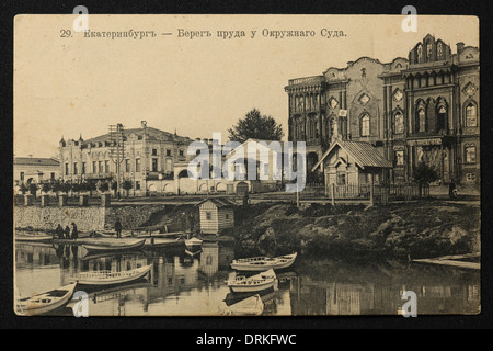 Tarasovskaya Embankment de la rivière Iset près du tribunal de district de Yekaterinburg, Empire russe. Photo vintage noir et blanc du photographe russe Veniamin Metenkov datée du début du XXe siècle, publiée dans la carte postale russe vintage publiée par Veniamin Metenkov lui-même à Yekaterinburg. Texte en russe: Yekaterinburg. La banque de l'étang près du tribunal de district. La rivière Iset forme l'étang de la ville (Gorodskoy Pond) dans le centre-ville de Yekaterinburg. Le tribunal de district aussi connu sous le nom de Maison de Sevastianov ou la Maison du Syndicat est le monument architectural du XIXe Banque D'Images