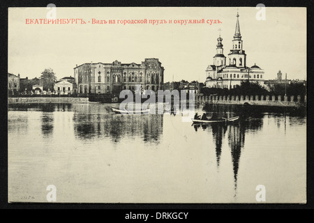 Cathédrale Sainte-Catherine et Cour du district sur la rivière Iset à Yekaterinburg, Empire russe. Photo vintage noir et blanc du photographe russe Nikolai Vvedensky datée du début du XXe siècle, publiée dans la carte postale russe vintage publiée par M.S. Semkov, Yekaterinburg. Texte en russe: Yekaterinburg. Vue sur l'étang de la ville (Gorodskoy Pond) et le tribunal de district. Le tribunal de district aussi connu sous le nom de Maison de Sevastianov ou la Maison du Syndicat est le monument architectural du XIXe siècle qui est maintenant l'une des résidences officielles du président russe. St Banque D'Images