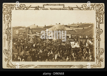 Célébration de la fête du travail en 1917 dans la ville de Krasnoufimsk dans les montagnes de l'Oural, Empire russe. Photo vintage noir et blanc des photographes russes les frères Popov datés du début du XXe siècle, publiée dans la carte postale vintage russe, publiée par les frères Popov eux-mêmes. Texte en russe: La ville de Krasnoufimsk. Fête du travail le 18 avril 1917. Krasnoufimsk est une ville de la région de Sverdlovsk, en Russie, située sur la rivière Ufa à 224 km de Yekaterinburg. Avec la permission de la collection de cartes postales Azoor. Banque D'Images