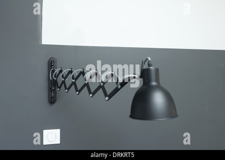 Lampe réglable noir monté sur mur gris. Banque D'Images