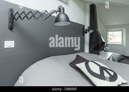 Chambre à coucher moderne avec lampe de nuit réglable monté sur un mur. Banque D'Images