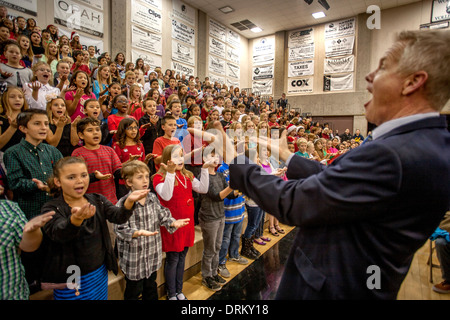 Un professeur de musique de l'école intermédiaire multiraciale dirige les enfants chantent des chants de Noël comme un groupe à un concert de l'école dans la région de Aliso Viejo, CA Banque D'Images