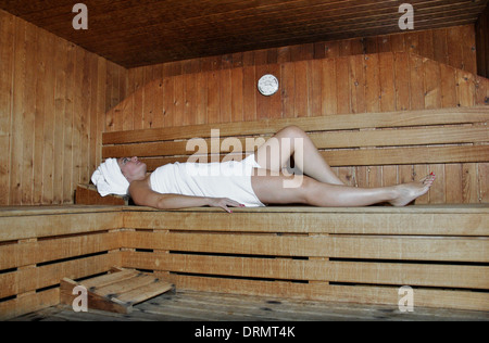 Woman relaxing in a sauna avec la chaleur Banque D'Images