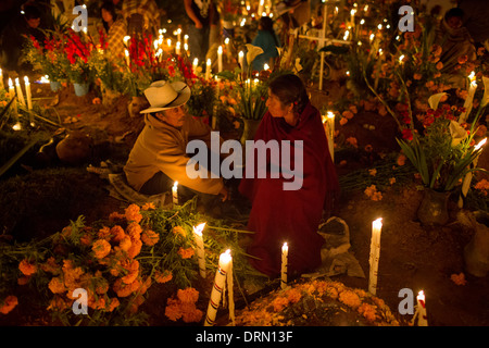 Une famille passe la nuit accompagnant la tombe d'un de leurs parents morts. Banque D'Images