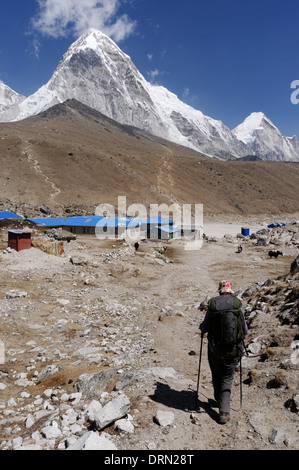 Une dame trekker arrivant à Gorak Shep, le dernier point sur le camp de base de l'Everest trek, au Népal avec le pic Pumori & Kala Pattar Banque D'Images