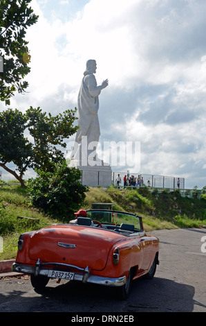 Statue du Christ de La Havane, Cuba, avec l'ancienne voiture décapotable orange Banque D'Images