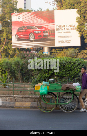 Une publicité pour les voitures BMW à Ahmedabad, Inde, contrastant avec les pauvres de la ville. Banque D'Images