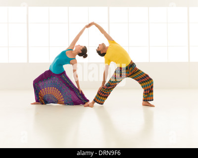 Belle femme avec un bel homme habillé dans des couleurs vives sont partenaires de yoga sport blanc Banque D'Images