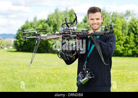 Technician Holding Octocopter UAV in Park Banque D'Images