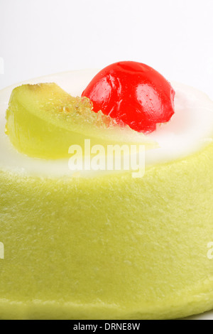 Extreme close-up of a mini Cassata Sicilienne avec des morceaux de fruits confits sur un fond blanc. Shallow DOF. Banque D'Images