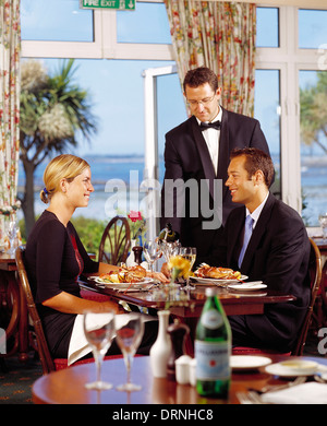 Waiter serving couple restauration l'hôtel. Îles Anglo-Normandes. Guernesey. Herm. Banque D'Images