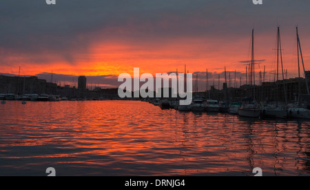 Coucher de soleil avec ciel rouge sur l'eau au vieux port d'eux-Port à Marseille, Provence, France, Europe Banque D'Images