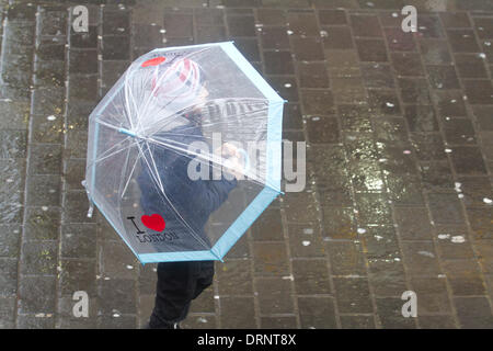 London UK. 30 janvier 2014. Un jeune enfant marche avec un grand parapluie voir à travers la pluie conditions continuent d'influer sur la capitale et de nombreuses partie du Royaume-Uni Crédit : amer ghazzal/Alamy Live News Banque D'Images