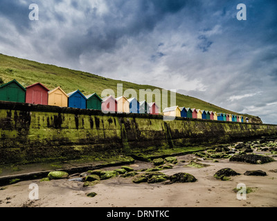 Cabanes de plage au pied de West Cliff, partie de Cleveland Way. Whitby, Yorkshire du Nord. Banque D'Images