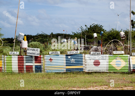 Drapeaux du monde peints sur le long de la route d'acier ondulé de Rincon à Kralendijk, Bonaire Banque D'Images