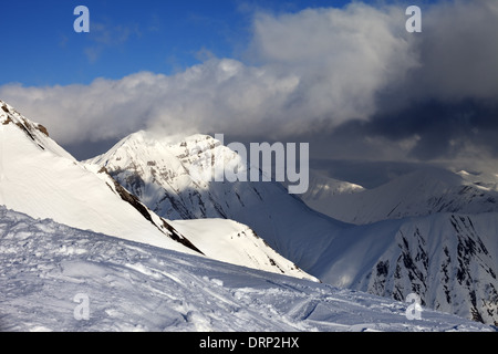 En hors-piste, pente et montagnes ensoleillées dans les nuages. Montagnes du Caucase, la Géorgie, ski de Gudauri. Banque D'Images