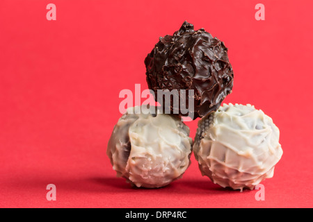 Truffels Choclate sur fond rouge. Banque D'Images