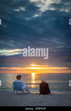 Deux femmes âgées bénéficiant d'un coucher de soleil sur la plage de Naples, Floride, USA Banque D'Images