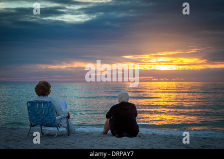 Deux femmes âgées bénéficiant d'un coucher de soleil sur la plage de Naples, Floride, USA Banque D'Images