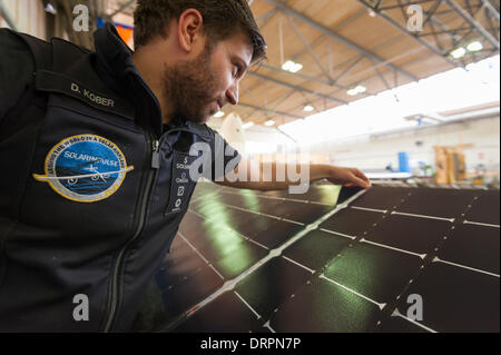 Dübendorf, Suisse. , 29 janv. 2014 : Un ingénieur du projet Solar Impulse est de l'équipe contrôle de la surface d'une cellule solaire-couverte de l'aileron de l'avion solaire expérimental 'Solar Impulse 2' (HB-SIB) qui est construit dans un hangar à Dübendorf (Zurich), Suisse. Pionnier de l'aviation suisse Bertrand Piccard a l'intention de voler l'avion solaire futuriste dans le monde en 2015. Crédit : Erik Tham/Alamy Live News Banque D'Images