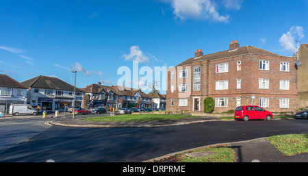 Vue d'un bloc d'appartements et de commerces défilé contre un ciel bleu, situé sur le côté de Nork and Banstead village, Surrey, Angleterre, Royaume-Uni. Banque D'Images