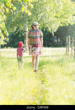 Petite fille et femme marche dans le vert paysage estival, Suède Banque D'Images