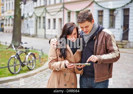 Couple de touristes dans une ville de la navigation avec un ordinateur tablette Banque D'Images