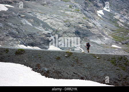 Randonneur avec équipement de camping sur le sentier du Glacier de l'Eiger par Eiger, Eigergletscher, Alpes suisses, en Valais, Suisse Banque D'Images