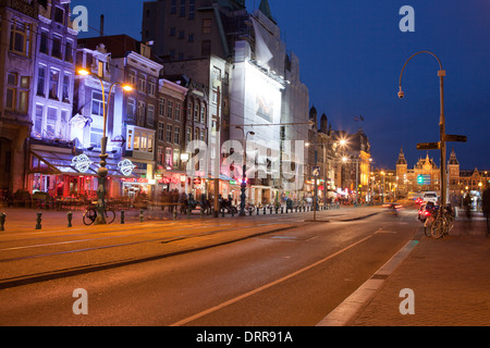 Damrak street dans le centre-ville d'Amsterdam dans la nuit, en Hollande, aux Pays-Bas. Banque D'Images