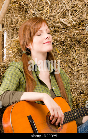 Pays jeune femme se détendre avec guitare Banque D'Images