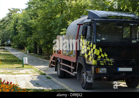 Camion bleu - eau-cart il prêt pour irriguer sur les fleurs dans le jardin public Banque D'Images